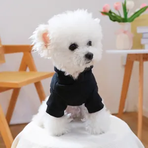 Detail of a black pet hoodie featuring a ribbed cuff and hood on a white Bichon dog