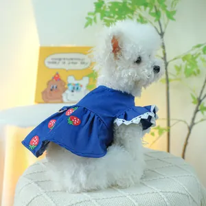 Dettaglio del ricamo a fragola e bordo in pizzo sul vestito di jeans per cani piccoli
