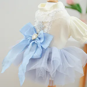 Detail of dog princess dress featuring lace collar, snowflake sequins, and a blue jewel bow