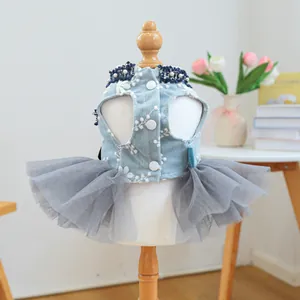 Détail de robe pour animal avec broderies florales bleues et tutu gris sur mannequin