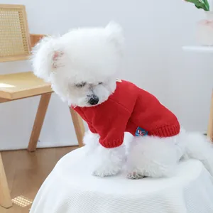 Close-up of a red knitted dog sweater with a classic diamond pattern and brand label
