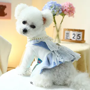 Detail of dog dress with lace embroidery, pearl buttons and blue mesh ruffles