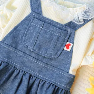 Dettaglio dell'abito in denim per cani con maglia gialla, pizzo e etichetta a cuore