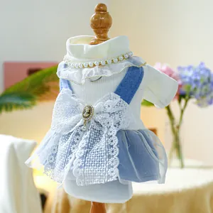Detail of pet dress with white lace bow and blue mesh skirt on small dog mannequin