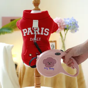 Detail eines roten Hunde-Hoodies mit PARIS-Stickerei und rosa ausziehbarer Hundeleine