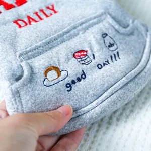 Detail eines weichen grauen Haustier-Sweatshirts mit Stickerei auf gestricktem Stoff