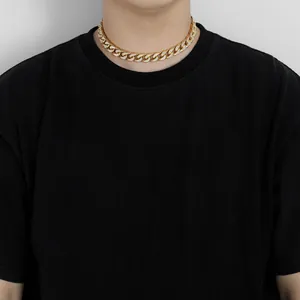 Detail van 12mm gouden Cuban link ketting met ingelegde zirkonia op een mannelijk model