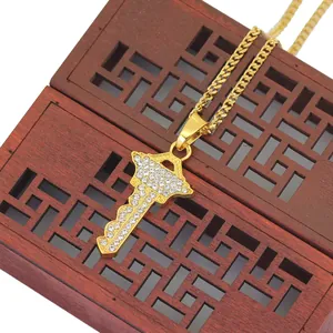 Collana hip hop con pendente a chiave dorata e cristalli su scatola di legno