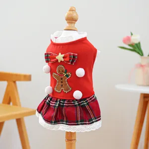 Macro detail of gingerbread embroidery and red plaid pleated skirt on pet Christmas dress