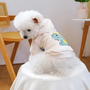 Close-up of a cozy pet hoodie with a cute green dinosaur print on white fabric