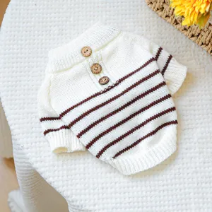 Detailed close-up of pet knit sweater with brown stripes and decorative wooden buttons