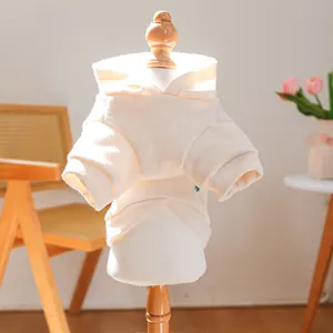 Close-up of soft white pet hoodie with ribbed cuffs on a small wooden mannequin stand