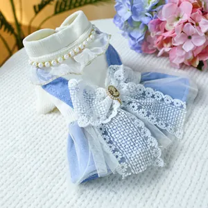 Detailed view of dog dress featuring blue lace ruffles with pearl neck and cameo brooch