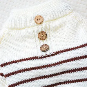 Detail of white pet knit sweater featuring natural wooden buttons and soft texture