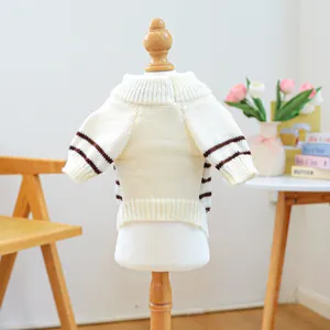 Close-up of cream pet knit sweater with brown striped cuffs on a mannequin
