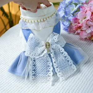 Close-up of pet dress showing white ribbed knit, lace bow, and vintage pearl chain detail
