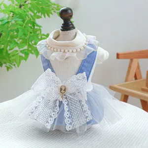 Detailed view of dog dress with lace bow, pearl collar and light blue mesh skirt
