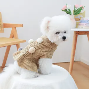 Detail of dog knit sweater with colorful plush balls and ruffled hem in khaki