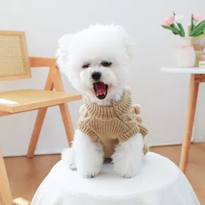 Close-up of beige knit dog sweater with thick textured patterns and high collar on a white dog