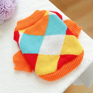 Detailed knit texture of a colorful argyle pet sweater with bright orange ribbed cuffs