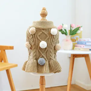 Detail of khaki knit pet dress with colorful plush pom-poms and ruffled hem for small dogs