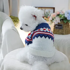 Close-up of Fair Isle knit pet sweater with navy ribbing on a white dog in warm home decor