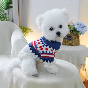 Close-up of knit pet sweater featuring blue wave patterns and red polka dots details