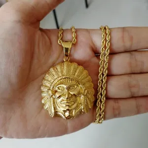 Detailed view of large golden Indian chief pendant on a thick rope chain held in hand