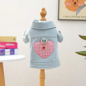 Detalle de chaqueta vaquera para mascota con parche de corazón rosa y colgante rojo