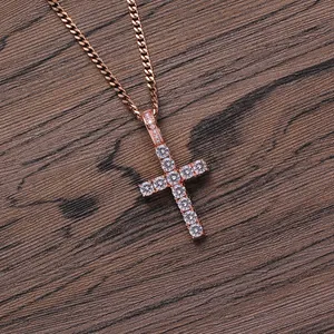 Close-up of rose gold Ankh cross pendant with micro-paved zircons on a wooden background