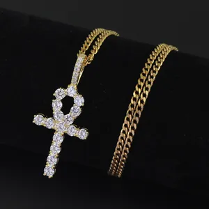Detailed view of hip hop Ankh cross pendant with micro-pave zircons and golden Cuban chain