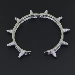 Detail eines silbernen Punk-Armbands mit vollem Zirkonia-Besatz und spitzen Metallnieten