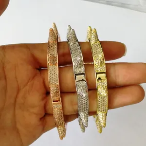 Nahaufnahme von drei besetzten Nietenarmbändern in Gold, Silber und Roségold mit Zirkon