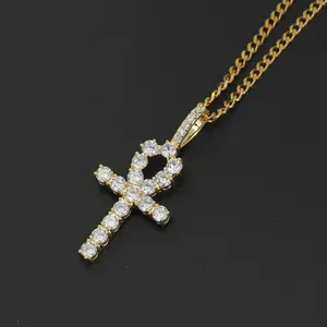 Detailed close-up of golden Ankh cross pendant with micro-pave zircons and Cuban chain