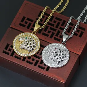 Macro detail of gold and silver leopard head pendants with sparkling crystal inlay