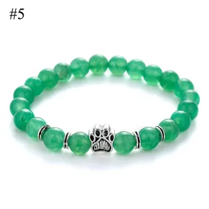 Macro view of green stone beads bracelet with silver dog paw print charm and metal spacers