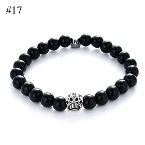 Detailed macro view of 8mm black stone bead bracelet with a silver hollow paw print charm