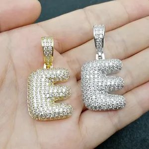 Dettaglio dei ciondoli lettera E a bolla in oro e argento con micro-pavé di zirconi