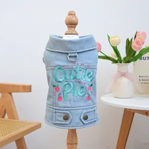 Detail of light blue denim dog vest with Cutie Pie embroidery and cherry pattern