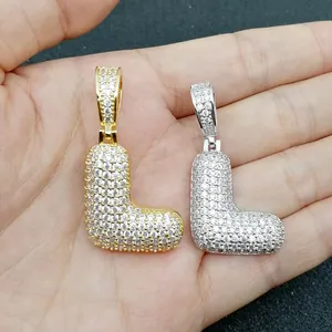Dettaglio dei ciondoli lettera L in oro e argento con micro-pave di zirconi lucidi