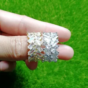 Dettaglio di anelli hip hop da uomo con zirconi rettangolari in finitura oro e argento