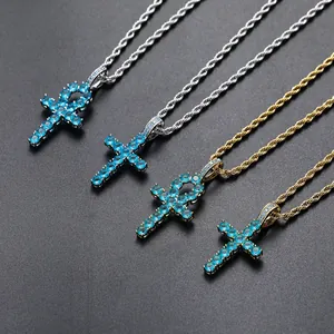 Detailed view of gold and silver Ankh and Latin cross pendants with blue zircon stones