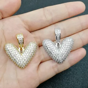 Dettaglio di pendenti a cuore in oro e argento con micro-pavé di zirconi bianchi