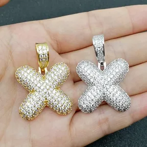 Dettaglio macro dei ciondoli lettera X in oro e argento con micro-pavé di cristalli