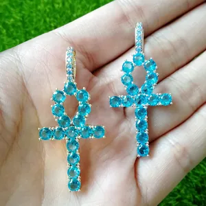 Detailed close-up of gold and silver Ankh cross pendants with bright blue zircon crystals
