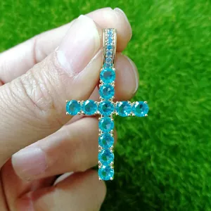 Detailed close-up of a gold-plated Ankh cross pendant set with blue cubic zirconia stones