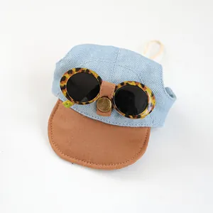 Detail of pet sun hat featuring denim texture, leopard print sunglasses and adjustable strap