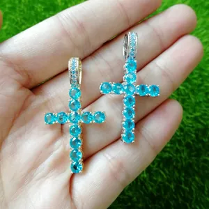 Detailed view of gold and silver Ankh cross pendants with inlaid bright blue crystals