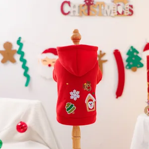Festive red pet hoodie with Christmas embroidery featuring reindeer and snow on a wooden stand