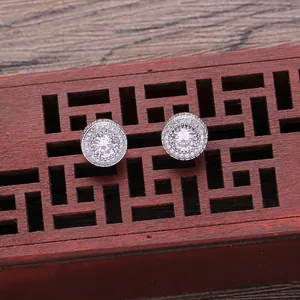 Detail of round halo stud earrings with cubic zirconia set on a vintage wooden gift box